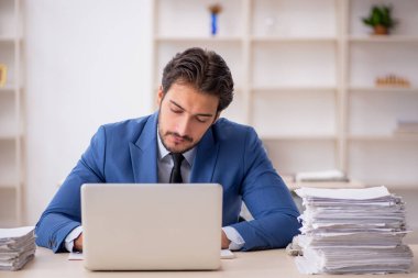 Genç işadamı ve ofiste çok fazla iş var.