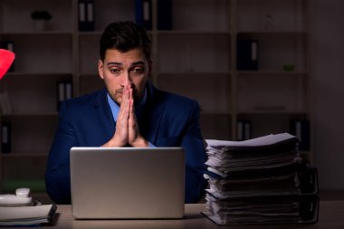 Young employee working late at workplace