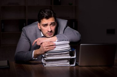 Young employee working late at workplace