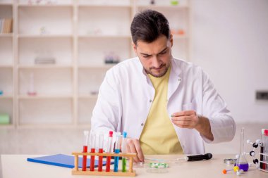 Young chemist sitting at the lab