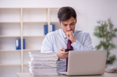 Genç işadamı ve ofiste çok fazla iş var.