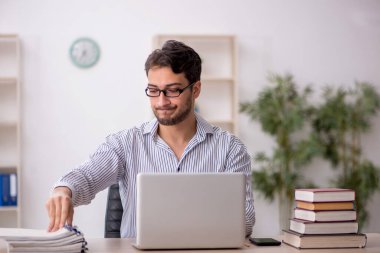 Genç erkek öğrenci işyerinde oturuyor.