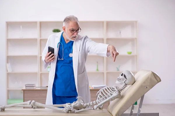Old male doctor and skeleton patient at the hospital