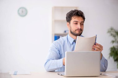 Genç bir çalışan ve ofiste çok fazla iş var.