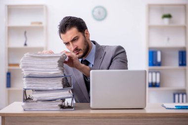 Genç bir çalışan ve ofiste çok fazla iş var.