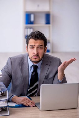 Genç bir çalışan ve ofiste çok fazla iş var.