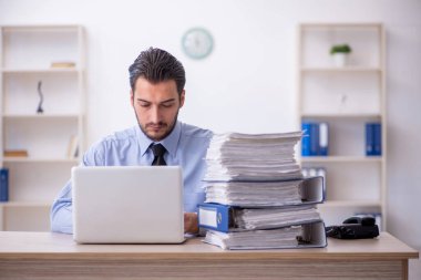 Genç bir çalışan ve ofiste çok fazla iş var.