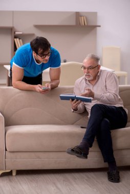 Young student and his grandfather at home