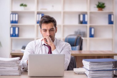 Genç işadamı işyerinde oturuyor.