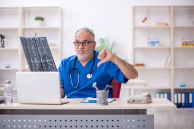 Klinikte çalışan yaşlı bir radyolog.