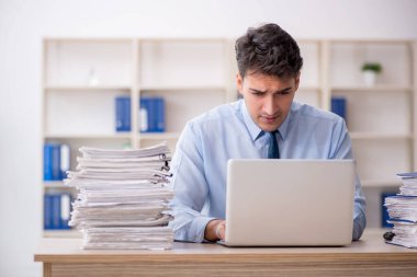 Young employee and too much work at workplace