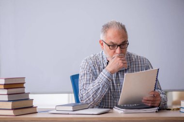 Old teacher sitting in the classroom