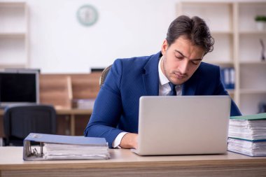 Genç işadamı ve işyerinde çok fazla iş var.