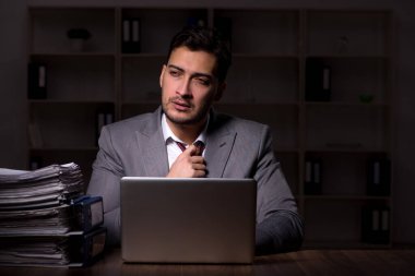 Young employee working late at workplace
