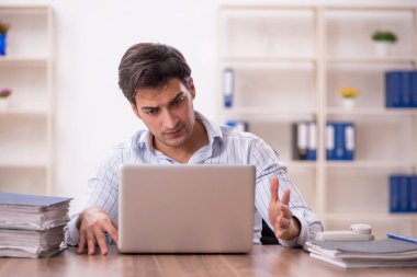 Genç işadamı ve işyerinde çok fazla iş var.