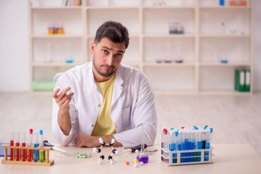 Young chemist sitting at the lab