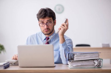 Ofiste telefonla konuşan genç bir çalışan.