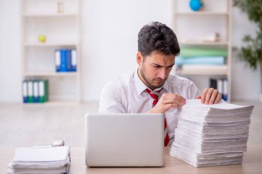 Ofisteki aşırı işten memnun olmayan genç bir çalışan.