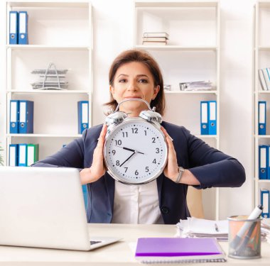 Ofiste oturan orta yaşlı bayan çalışan.