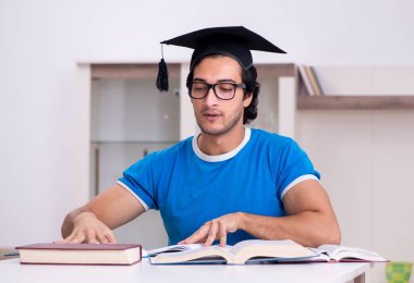 Genç ve yakışıklı öğrenci evde çalışıyor.