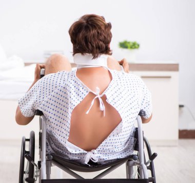 Hastanedeki tekerlekli sandalyedeki genç adam.