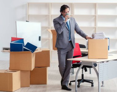 Ofiste kutuları olan genç adam.