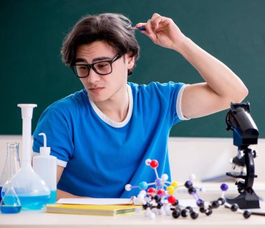 Sınıftaki genç erkek öğrenci.