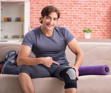 Genç yakışıklı adam evde spor egzersizleri yapıyor.