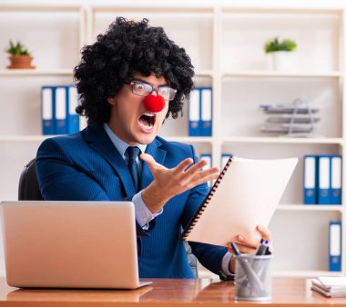 Ofiste çalışan genç palyaço işadamı.