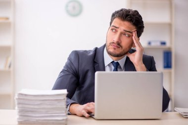 Genç bir çalışan ve ofiste çok fazla iş var.