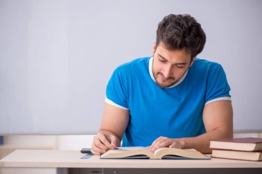 Genç öğrenci beyaz tahtanın önünde.