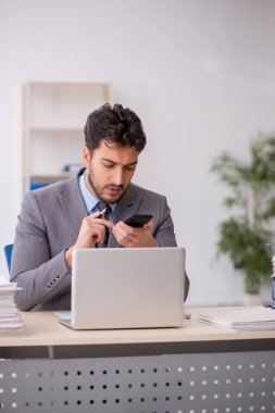 Genç bir çalışan ve ofiste çok fazla iş var.