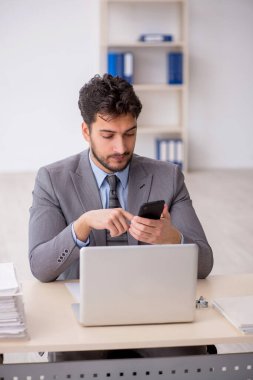 Genç bir çalışan ve ofiste çok fazla iş var.