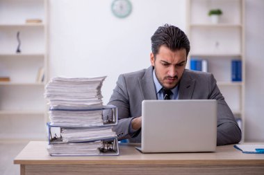 Genç bir çalışan ve ofiste çok fazla iş var.