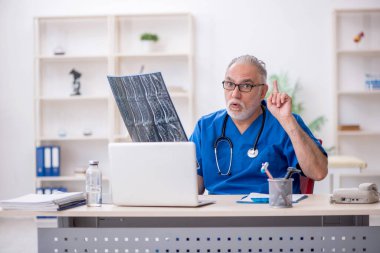 Klinikte çalışan yaşlı bir radyolog.