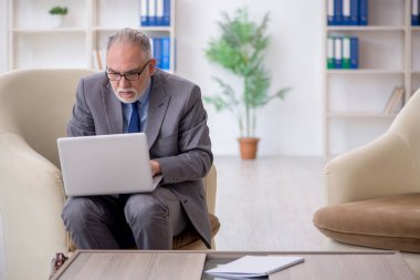 Koltukta oturan eski bir çalışan.