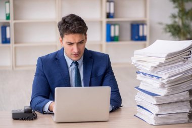 Young employee and too much work at workplace