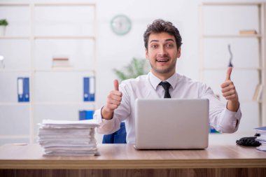 Young employee and too much work at workplace