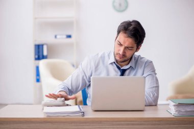 Genç işadamı işyerinde oturuyor.