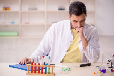 Young chemist sitting at the lab