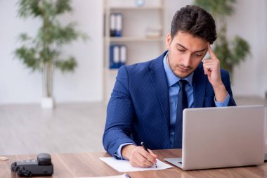 Genç bir çalışan ve ofiste çok fazla iş var.