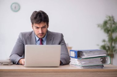 Genç işadamı işyerinde oturuyor.