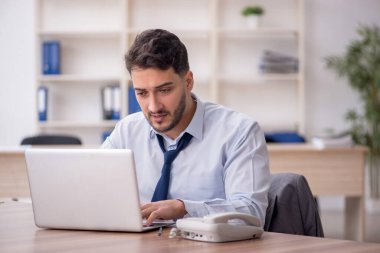 Young employee and too much work at workplace