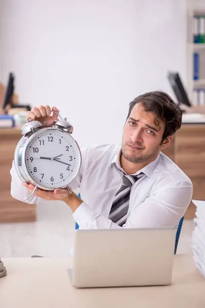 Young businessman employee in time management concept