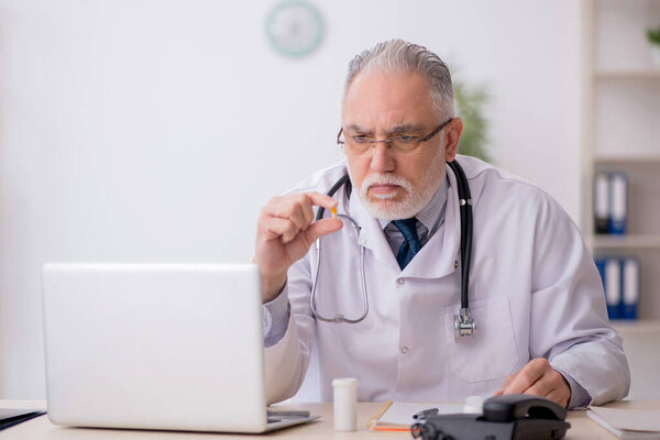 Old doctor suggesting pills at the hospital