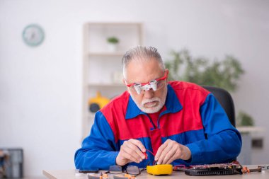 Laboratuvarda eski bir tamirci bilgisayar tamir ediyordu.