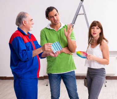 Ev yenileme konseptinde genç çift ve yaşlı müteahhit.