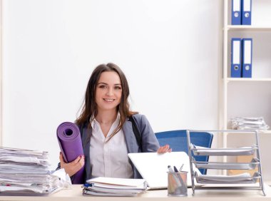 The female employee doing sport exercises in the office