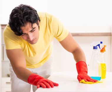 Ev işi yapan yakışıklı genç adam.