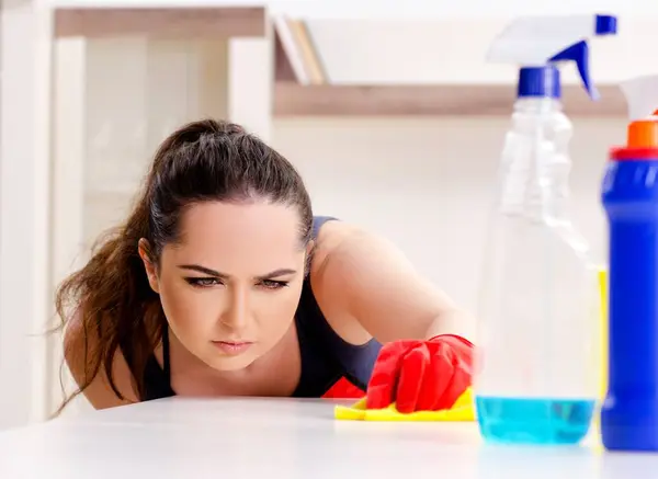The young beautiful woman cleaning apartment